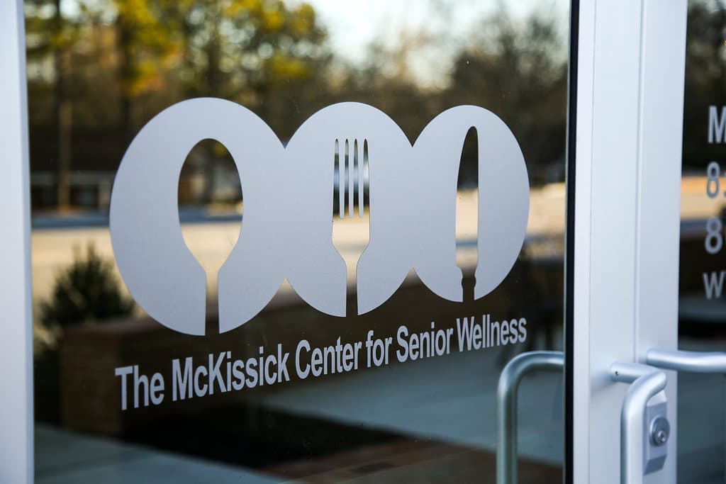 Volunteer hands off a hot meal to a senior at their door