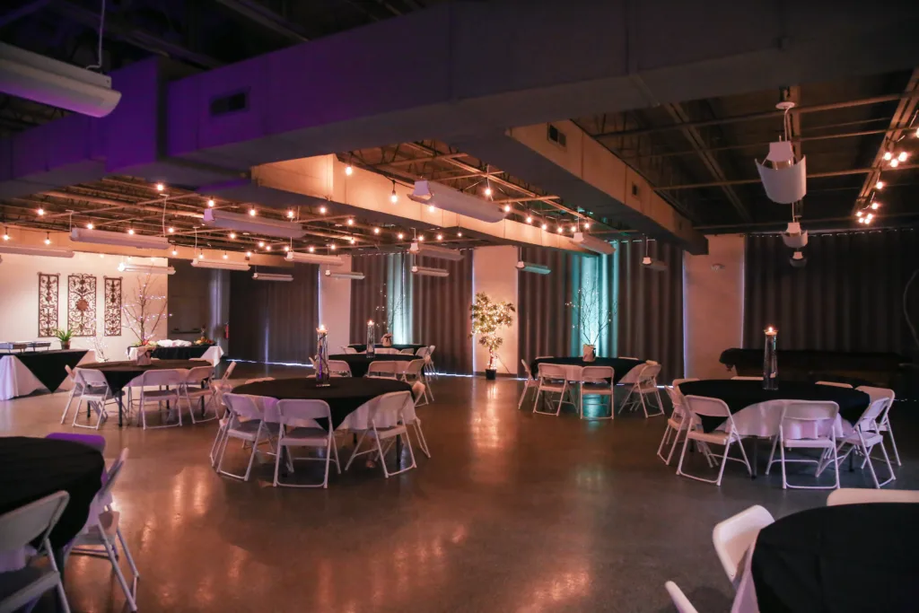 The McKissick Center dining hall set with round tables, white chairs, and warm string lights overhead.